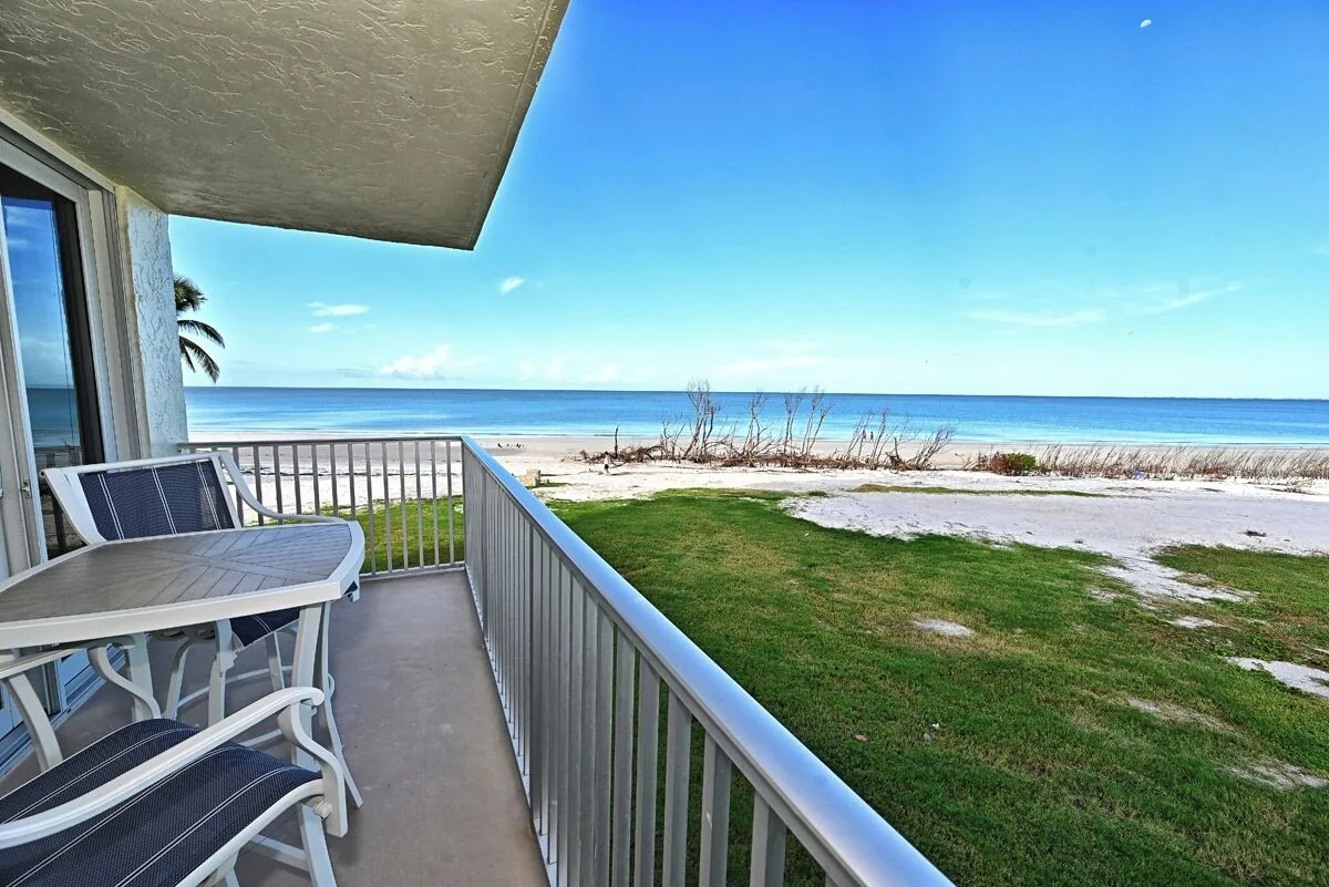 Balcony table and chairs with ocean view for outdoor dining at Beachfront Haven