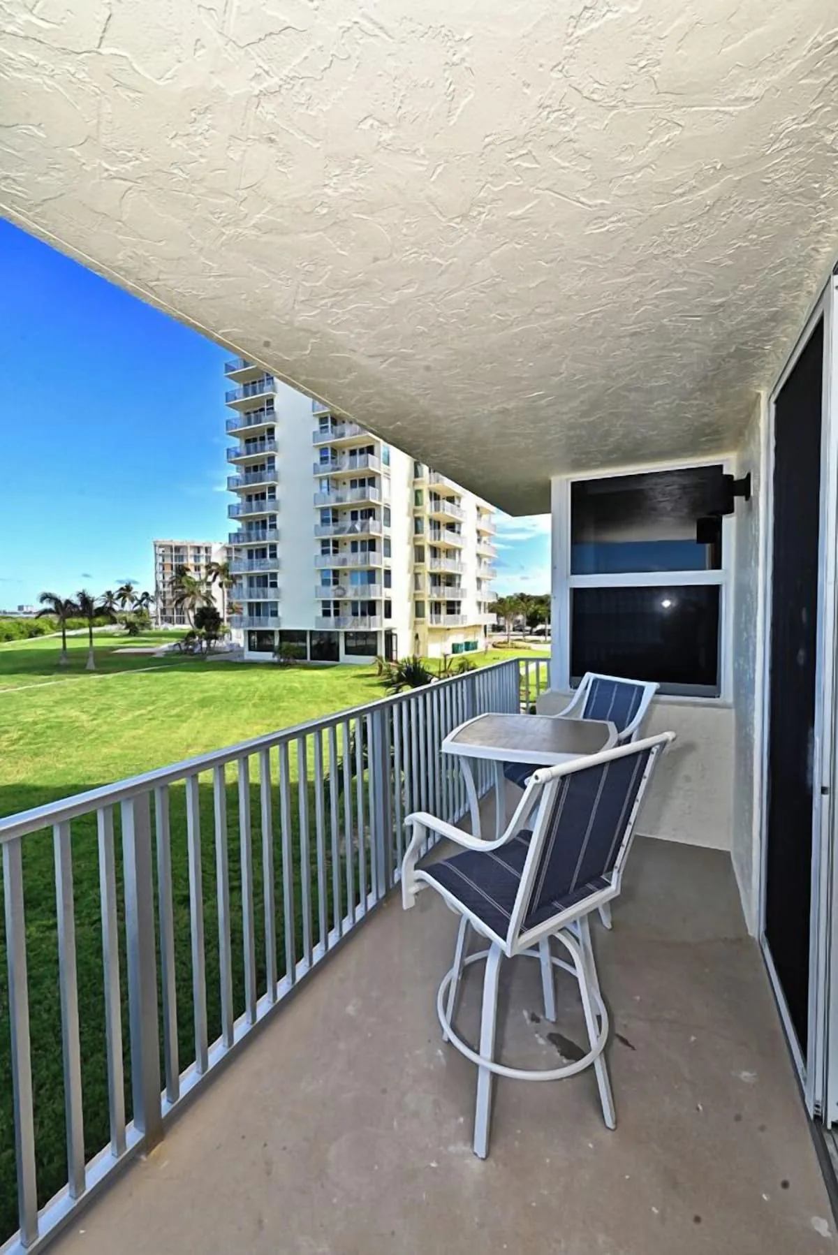 Balcony seating area overlooking the grounds at Beachfront Haven