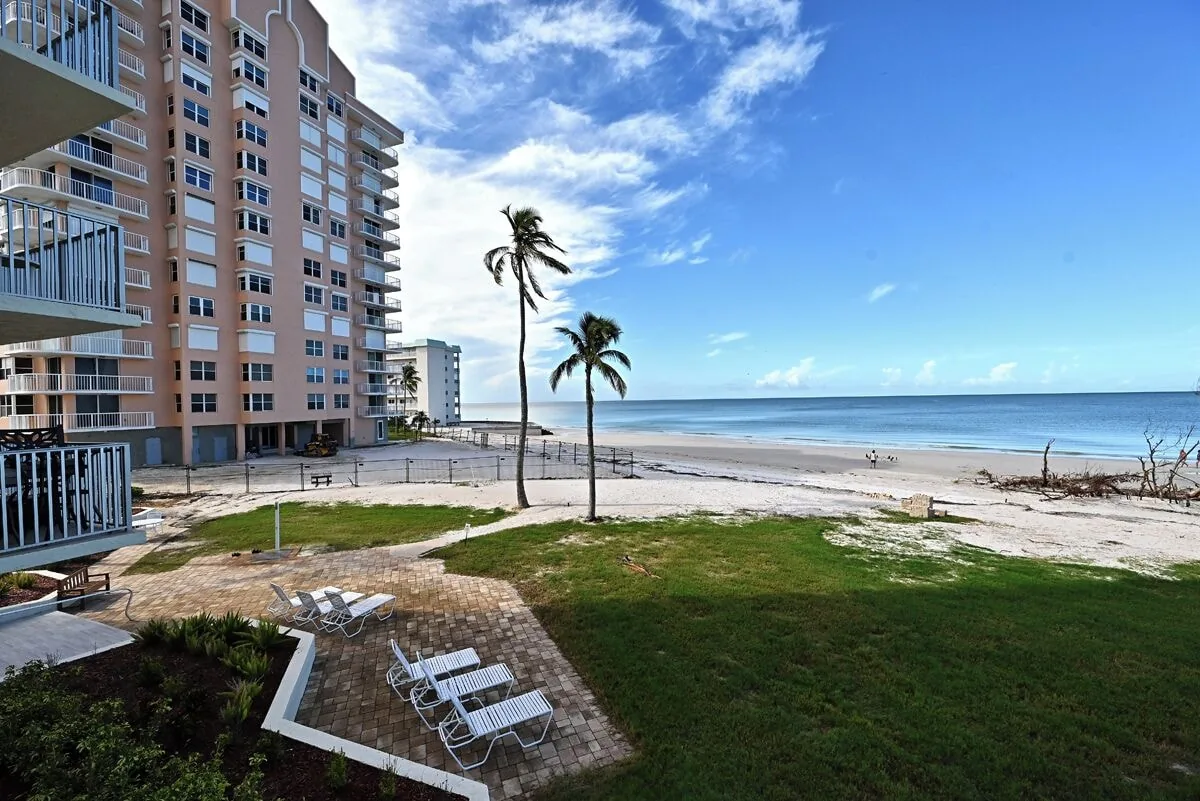 Beachfront building with pool and grounds at Estero Beach & Tennis Club