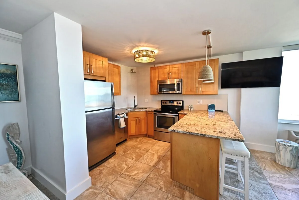 Kitchen with cabinets and pendant lighting at Beachfront Haven